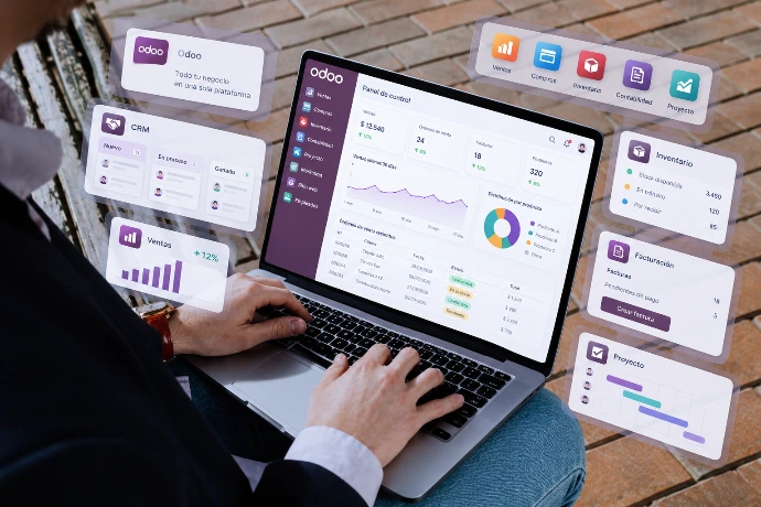 Persona usando un laptop con el panel de Odoo y tarjetas flotantes de módulos como CRM, Ventas y Productos